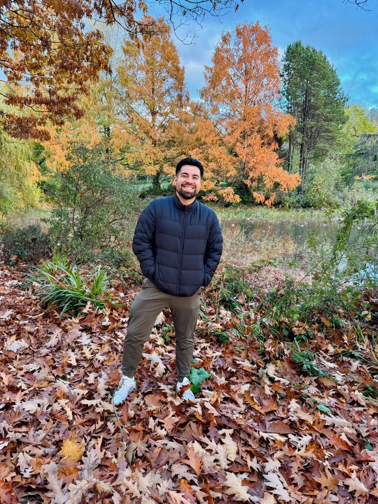 Javier standing in autumn leaves in a Vancouver park