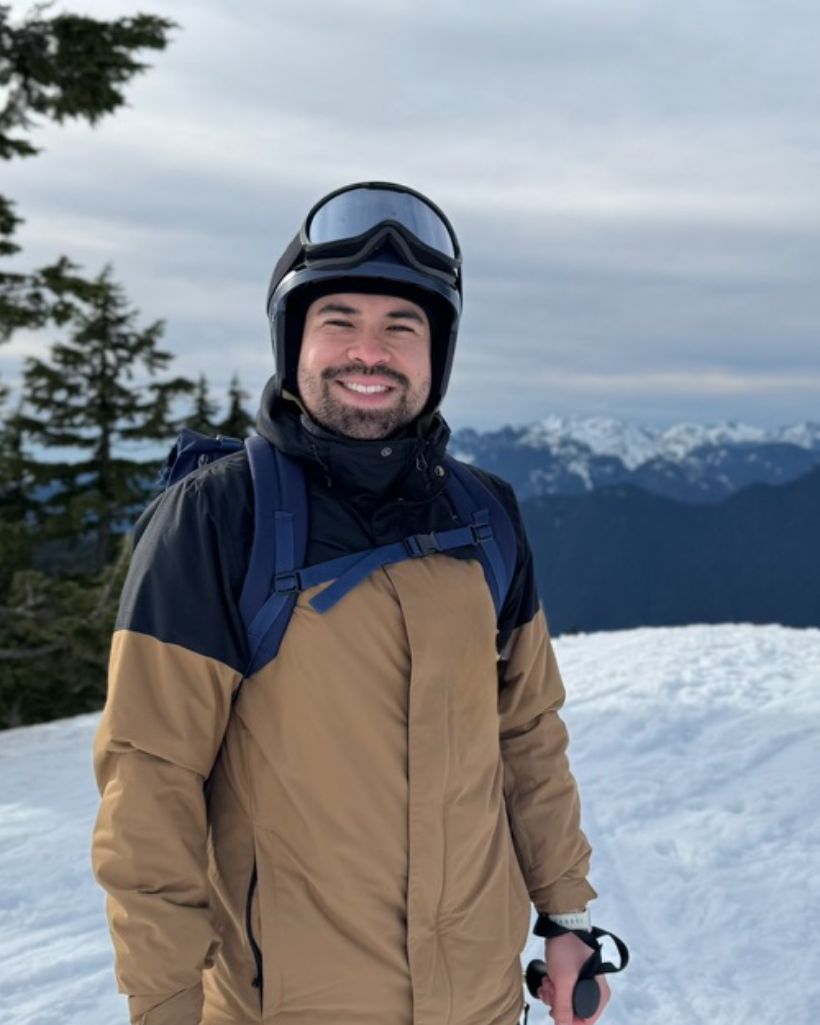 Javier on a snowy mountain above Vancouver on a grey day